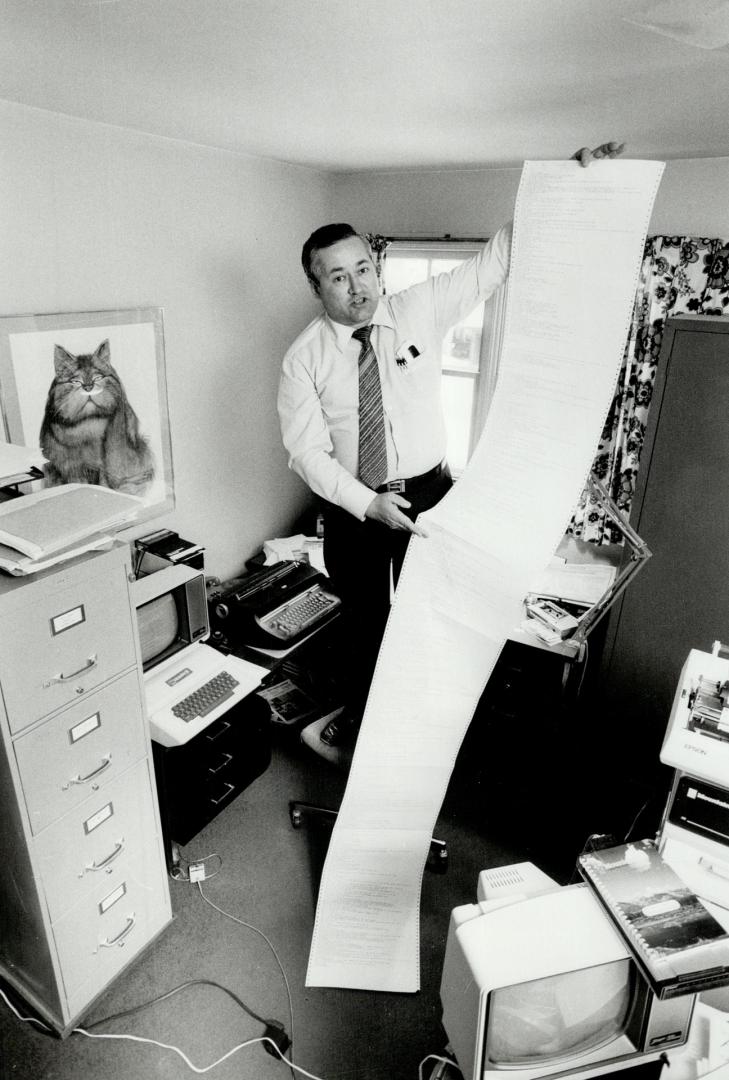 Pages of work: Graham Newton, 43, holds up the complcated computer instructions he's developed for running his 4 1/2-year-old electronic bulletin board from a tiny office at home