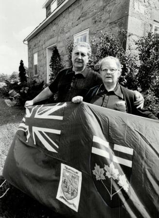 Revoluntionary banner: Maurice and Elva Newton are so confident they'll win battle to turn backe clock and get rid of regional government that they've made a new flag, adding the former Nassagaweya township emblem to the Ontario flag