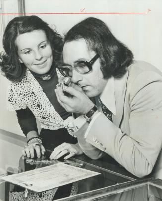 Piece of Jewelry gets expert appraisal from jeweller Russell Oliver, while his wife Barbara looks on, Owner of the gems may be surprised when Oliver tells her the value of her jewels today, since prices have skyrocketted