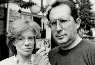 Gypsy, come home: Cheryl and Jack Osten hold identification card for their Hearing Ear dog, Gypsy, which disappeared Thursday