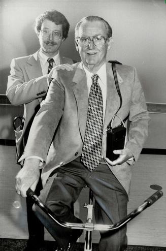 Life-saving machine: Patient Jack Hayward exercises at Oakville-Trafalgar Memorial Hospital while wearing the Holter Monitor which warned doctors he would have a heart attack. Dr. Donald G. Peat is at left.