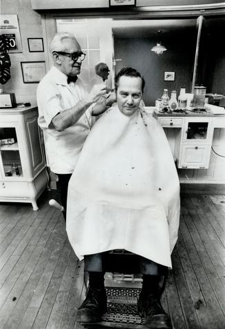 Avard Porter, 75, and a barber for 60 years, gives a trim to customer Forrester Lowe