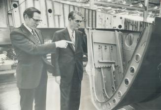 Leading edge of a 25-yard-long wing for a giant DC-10 airliner-wings are a specially at Malton's Douglas Aircraft of Canada- is examined by the firm's treasurer, Chuck Gollihar, left, and president Dick Richmond, Douglas Canada makes major parts of airpla