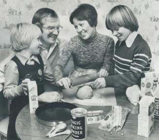 As wife and mother Gwyn Reid bakes a cake surrounded by husband Melvin and sons Paul, 8, and Garth, 11