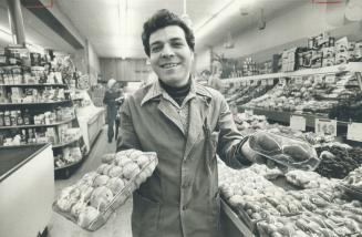 Joe Rinella proudly holds up some of the fresh produce that has helped lure a loyal band of customers to his Carlton Food Mart -- and enabled him to compete against the country-wide chains