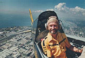 Master of Manoeuvre: Frank Ryder files his stunt plane above Toronto yesterday.