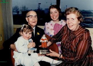 Four generations: Great-granddaughter Karen Barber, 3, granddaughter Lois Barber 28, and daughter Esther Campbell (right) help Judge John Prentice celebrate his 100th birthday yesterday at St