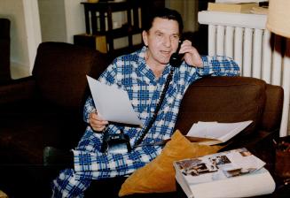 Dialing a deal: Retired Carl Prucha, above, still in his pyjamas, makes a financial transaction.
