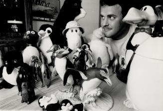 Fowl friends: Ken Quigley displays some of the many avian houseguests sent to him by friends after he complained of a dearth of penguin artifacts.