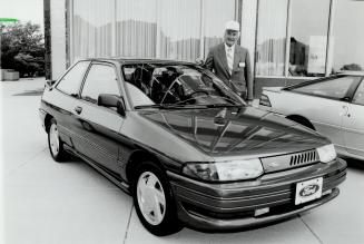 New Escort: Jon Rideout, product plans manager for Ford of Canada, stands beside the 1991 Escort GT, a competitor to the Toyota Corolla and Honda Civic