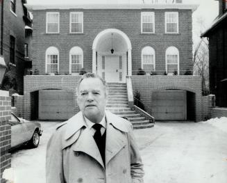 George Robb stands in front of the contemporary Georgian house he redesigned with courtyard, porch and recessed garages