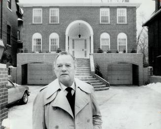George Robb stands in front of the contemporary Georgian house he redesigned with courtyard, porch and recessed garages