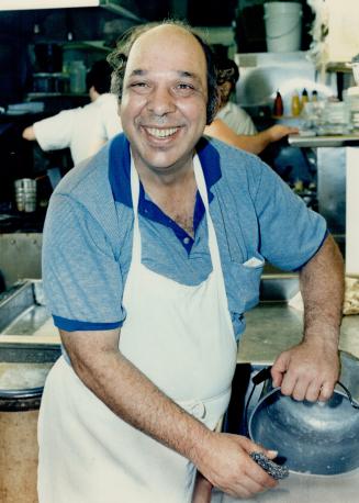 On his own: Paul Roy scrubs a pot at his dishwashing job at the Sunrise Restaurant.