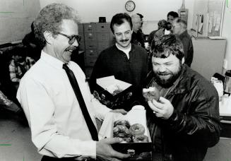 Welcome back: Larry Running, right, nearly killed in a downtown manhole blast in 1987, is greeted with doughnuts at work yesterday at Unitel on Keele St