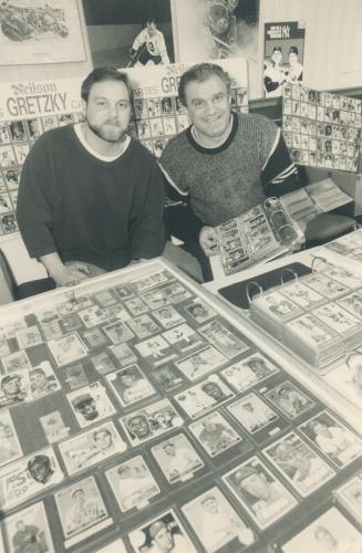 Pick a card: Angelo Savelli, right, of Hamilton, and his son Mark set up shop with a part of Angelo's million-dollar bubble gum card collection yesterday at a collectables show in Scarborough