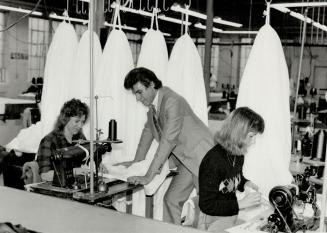 Plunging into work: John Simis likes to look in on the parachute making the Erika Nepp (left) and Diane Schmidt have in hand at Irvin industries Fort Erie plant