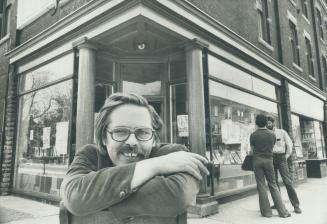 Taking a tour of his domain, John sime rests outside one of his several book stores