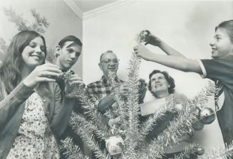Now, They're looking forward to Christmas with happy smiles, as family of General Morotrs worker Tom Simmons decorates Christmas tree