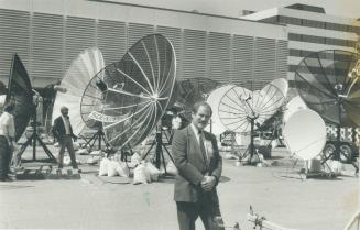 Data dishes: Samuel Singer, chairman of the Satellite Communications Association of Canada, stands amid some of the dozens of satellite receiving dishes at the Skyline Hotel