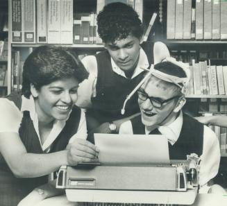 Using his head: Rick sipos, right, shows fellow students how, by using a device strapped to his head, he typed an essat on Orwell's Nineteen Eighty-Four that won his school's literary contest