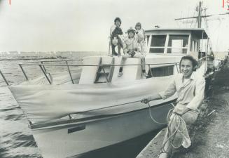 Ready to cut loose for the summer, former salesman George Skea, 37, holds mooring lines of the 42-foot houseboat he designeed and built, where the family will live this summer