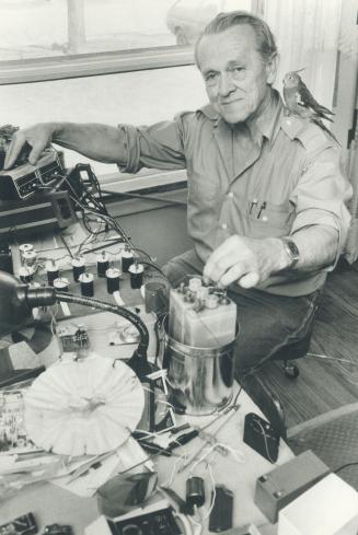 Inventor at work: Carl Smith and his cockatiel, Pretty Bird, test his latest invention