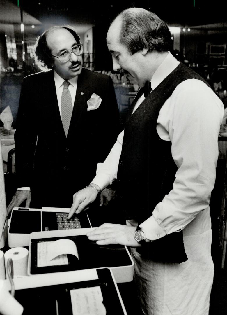 Placing order: Computer cuts costs for restaurant co-owner Mostafa El Sayed (above, left), steps to kitchen for waiter Andrews loding, and aggravation for chef Gus Nikoletsos (right) because it prints readable orders