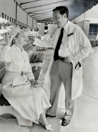 Proper fashion: John Schuman, medical director of Providence Villa and Hosptial, admires Mary Willoughby's hat, a perfect screen for the hot rays of sunlight