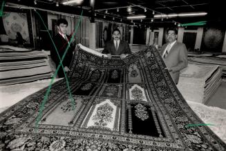 Fine work: Shashi Sharma, right, and his sons Nav, left, and Ben show off a Muslim prayer rug, one of the $8 million worth of oriental floor coverings their Indo-Persian Rug Co