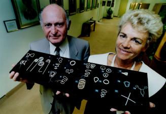 Percy Skuy, president of Ortho Pharmaceutical, and curator Heather Bennett with a display of IUDs.