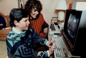 Stacey Slater and his mom Debbit try out the computer that will keep Stacey in touch with his classmates and school studies