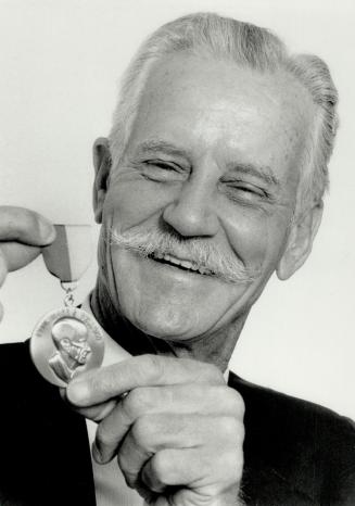Rotary award: Charles Snider, 67, of North York, holds up the Paul Harris Fellow medal he recived from the Rotary Club of Woodbridge for his 13 years of work in Third World countries