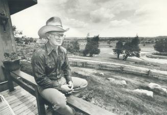 Mel Stevens sits on a cabin railing looking out over Teen Ranch, a summer camp run on Christian principles, which he started in 1967.
