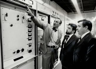 Transmitters for Mexico: Lou Spence, left, general manager, broadcast equipment, at Canadian General Electric, points out details of television transmitting equipment bought by Mexican television network