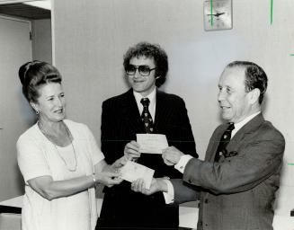 Marshal Stearns accepts cheques from Margaret Birch, Ontario secretary for social development, and Paul Godfrey (centre)