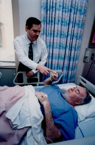 Stroke Prevention: Dr. Bradley Strauss shows Magnus Mackay a stent like those inserted in his carotid arteries.