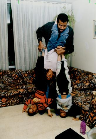 Sutton antics: Chris Sutton, a single father since 1989 when his wife died, gives the kids a hand with their handstands in their Parkdale home