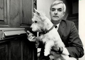 Tiny terror: Robert Swayze holds his 23-centimetre (nine-inch) tall West Highland terrier Birder, who has kept the mailman away from Swayze's townhouse for two months by snapping at the mail slot - and the carrier's fingers - during mail delivery