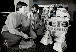 You don't say!: Dr. Paul Turner and his wife, Annice, from Perth, Ont. stopped to chat with two talking robots when they registered for the annual OMA meeting yesterday at the Harbour Castle Hilton hotel. Geigy is not from Star Wars, but he is one of the latest technicological advances.