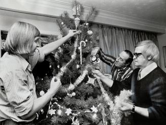 Ex-convicts Frank (left) and Jim help Harold King (right) decorate Christmas tree at farm where King helps men just released from prison prepare for return to normal society