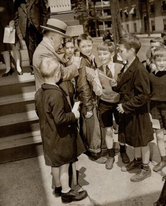 His popularity never waning, he was greeted by this group of autograph-seeking children as he left an Ottawa polling place after casting his ballot in yesterday's election