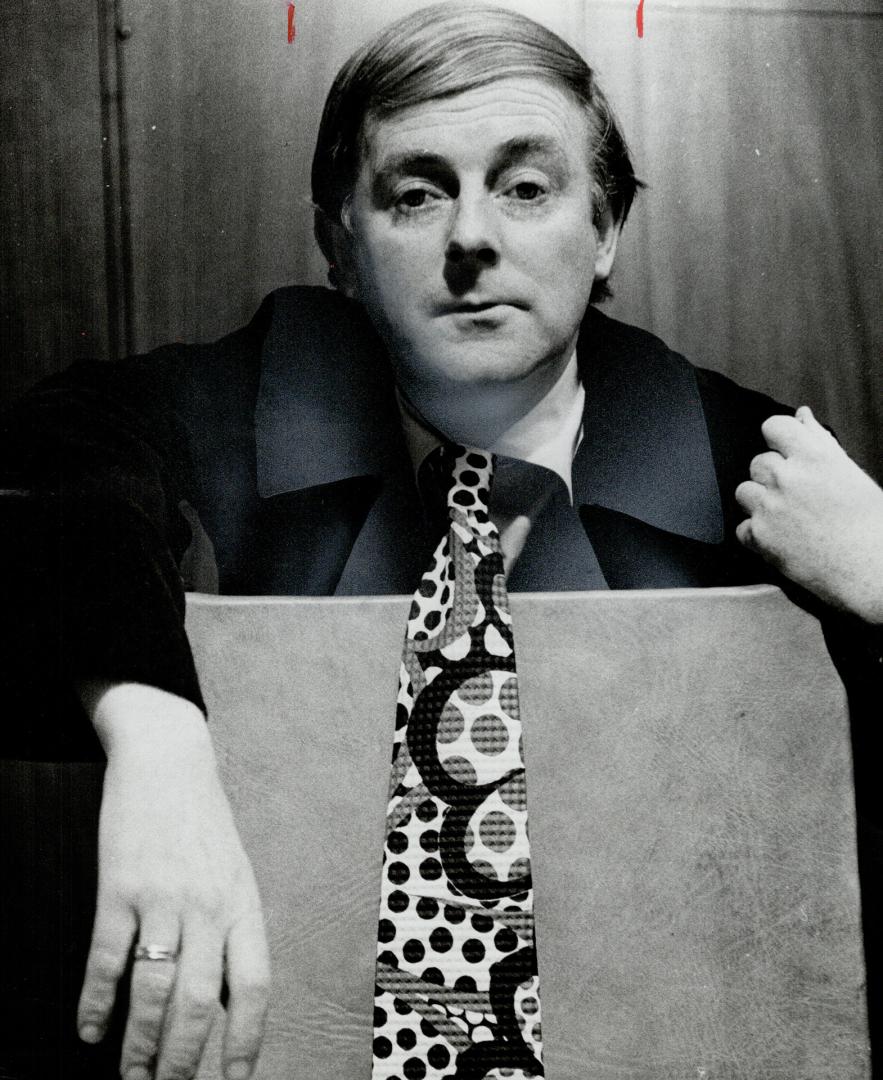 Tom Kneebone, actor, shows off his wild abstract print tie with its half circles and polks dots. I like the patterned ties for color, he says.