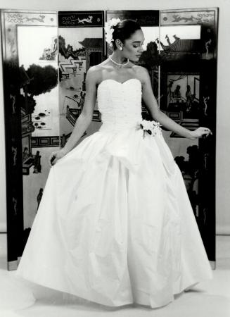 Silky opulence: Above, white silk paper taffeta strapless wedding gown has pearl encrusted bodice and crinoline skirt