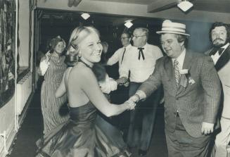 Whooping it up at the Mississippi Riverboart, Leon Kossar, chairman of Caravan '74, dances with Lisa Russell