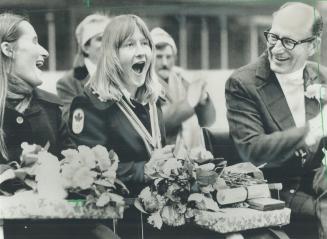 Back home in Timmins with Canada's only first-place gold medal from the Winter Olympics, skier Kathy Kreiner is applauded by her father, Dr. Harold Kreiner (right), and 1,000 other people in the Community Sportsplex. About 200 well-wishers greeted her at the tiny Timmins airport, others lined the seven-mile road into town. Kathy surprised the ski world by winning the women's giant slalom.