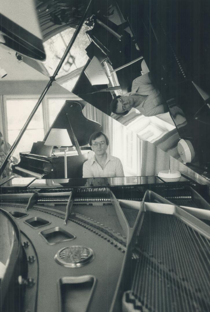 Piano man: Toronto composer and conductor Gary Kulesha is reflected in the lid of his grand piano