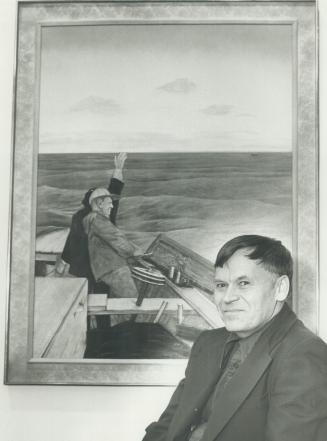 William Kurelek, the artist, sits in front of one of his works.