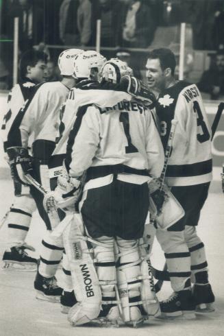Nice job: Weary Leaf goalie Mark Laforest, 46 shots later, draws a smile from Brad Marsh and a hug from Lou Franceschetti