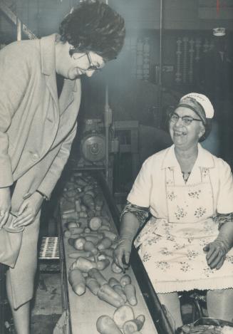 Liberal candidate Judy LaMarsh, left, minister of national health and welfare, talks with a worker on the carrot processing line at baby-food plant in Niagara Falls