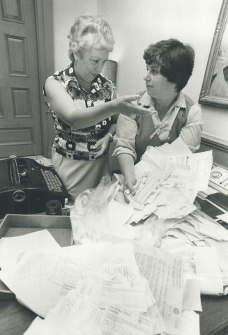 Michele Landsberg (right) leaves coupons with secretary Margaret Aikins
